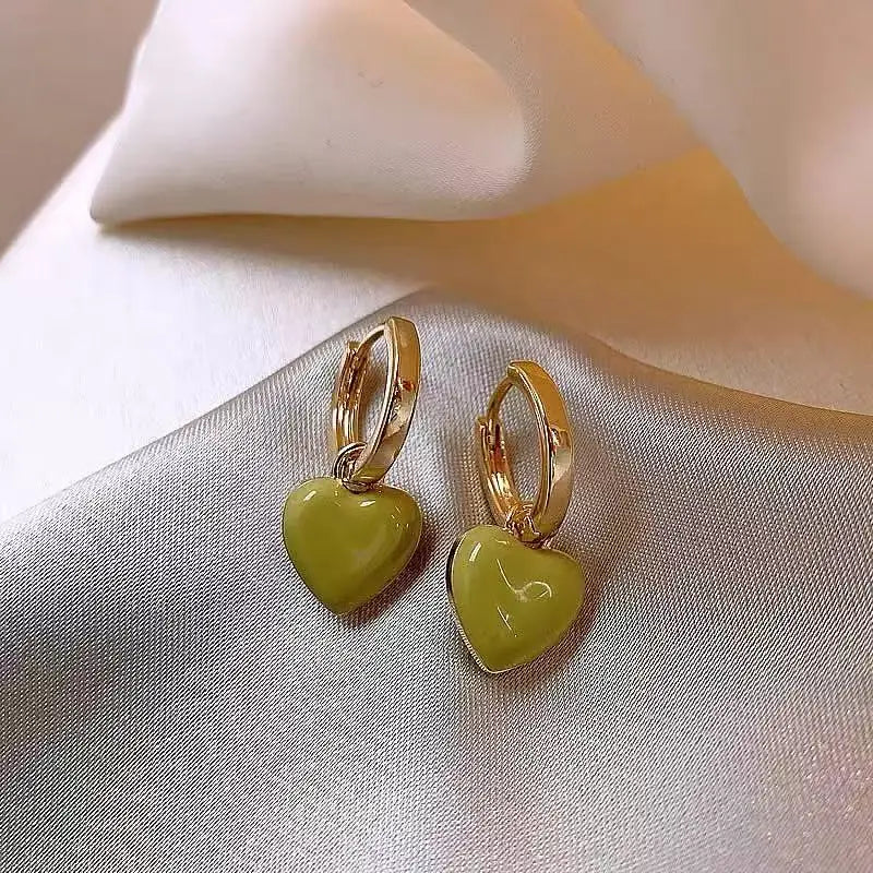 Heart-shaped earrings with gold rims on a soft fabric background
