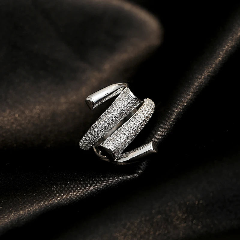 Silver ring with diamond accents on a dark fabric background