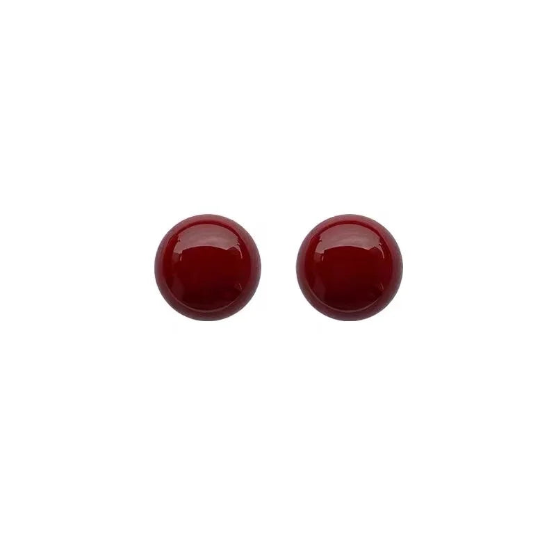 Pair of round red earrings on a white background