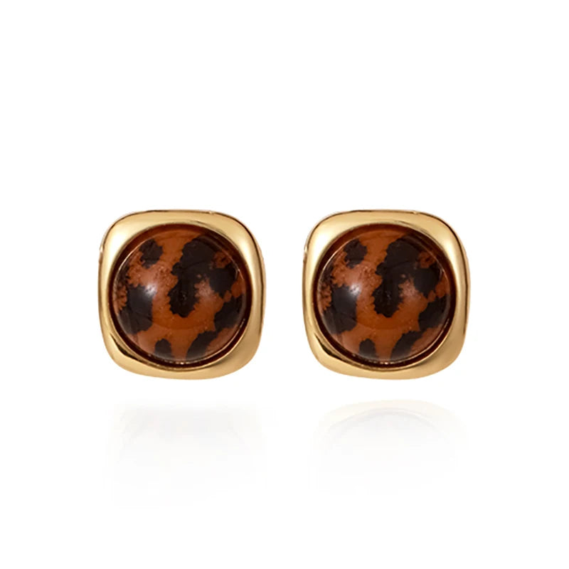 Gold-framed tortoiseshell stud earrings on a white background