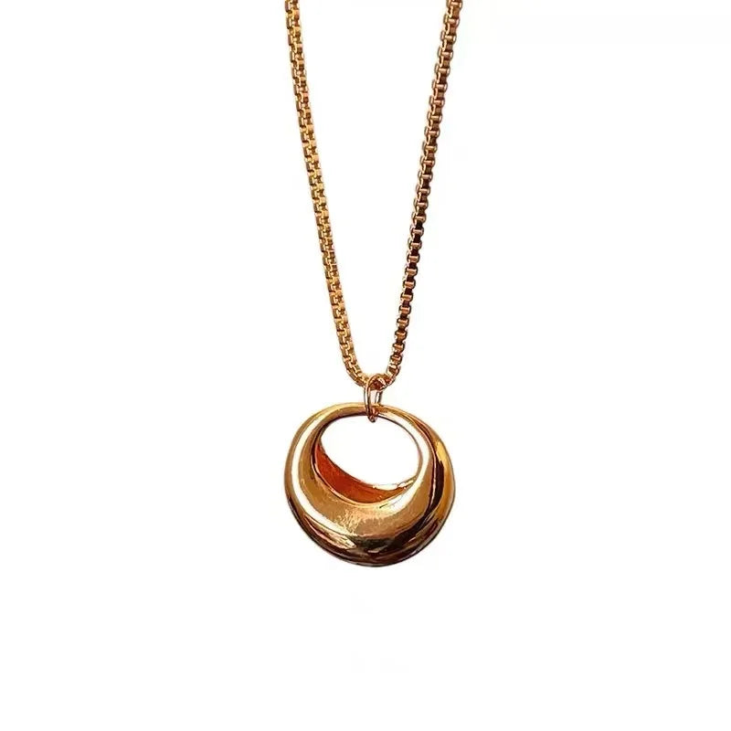 Gold necklace with a double-circle pendant on a white background