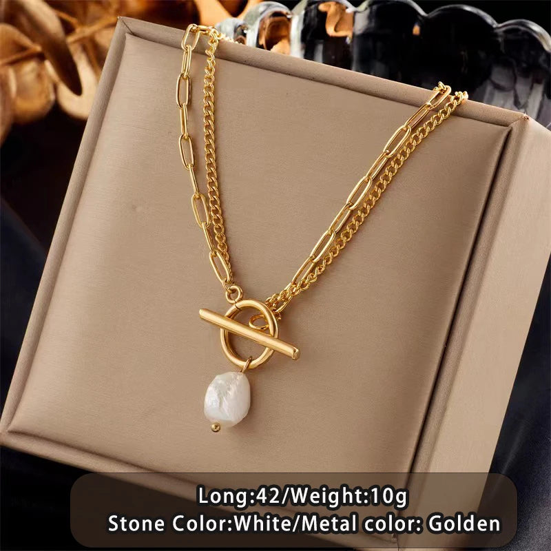 Gold necklace with a white stone pendant on a beige box