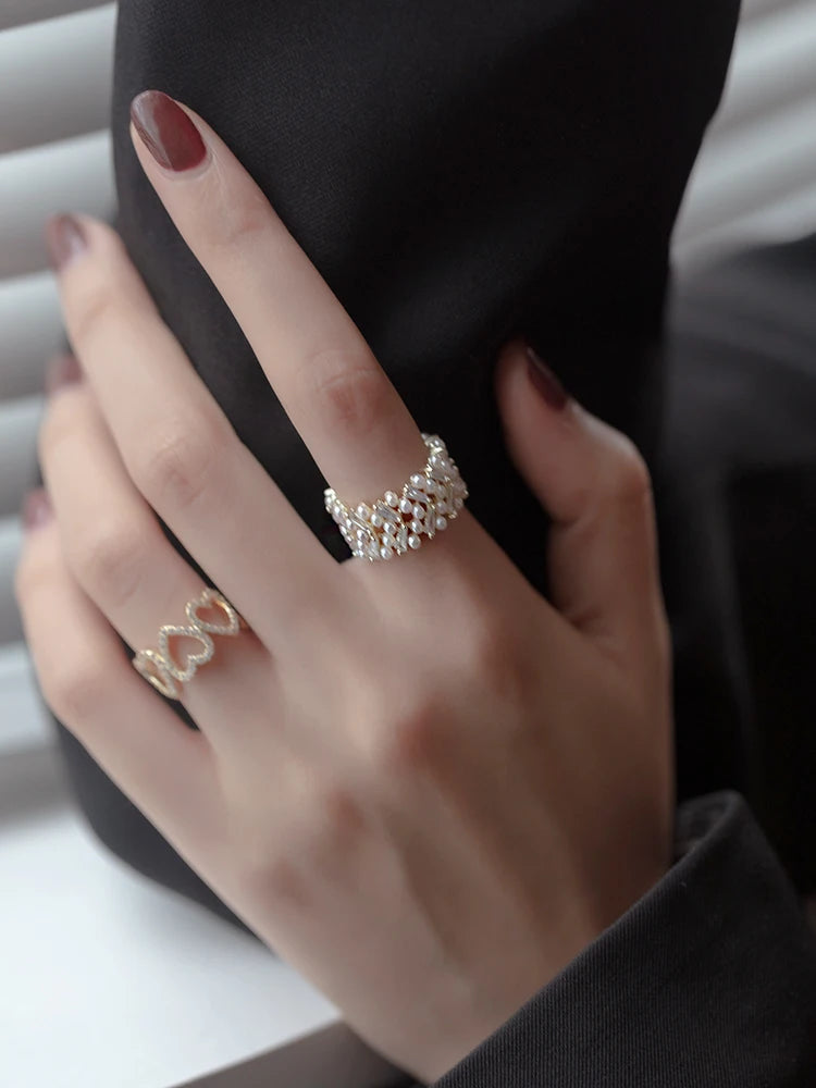 Hand wearing two rings with a blurred background