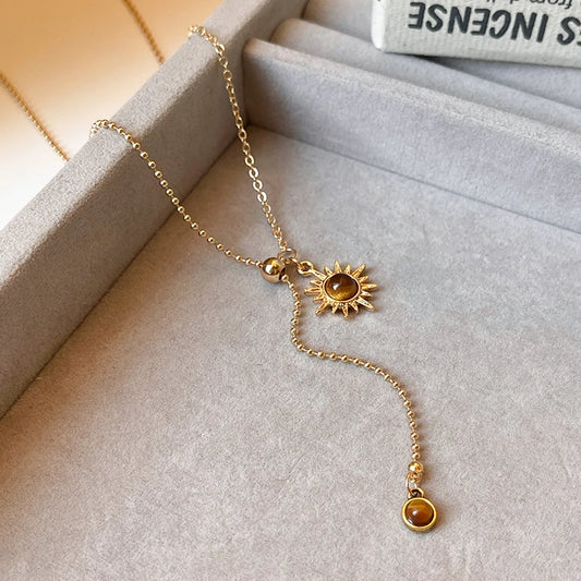 Gold necklace with sunflower pendant on a soft surface