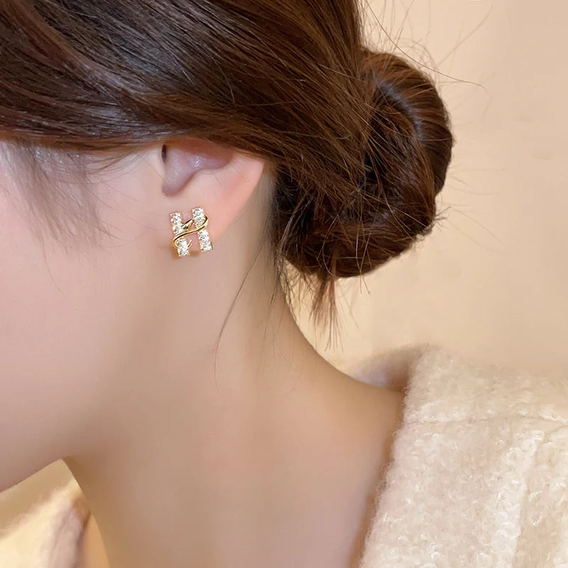 Gold earring worn by a person with a blurred background