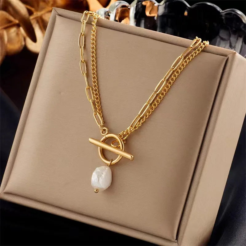 Gold necklace with a pearl pendant on a beige box