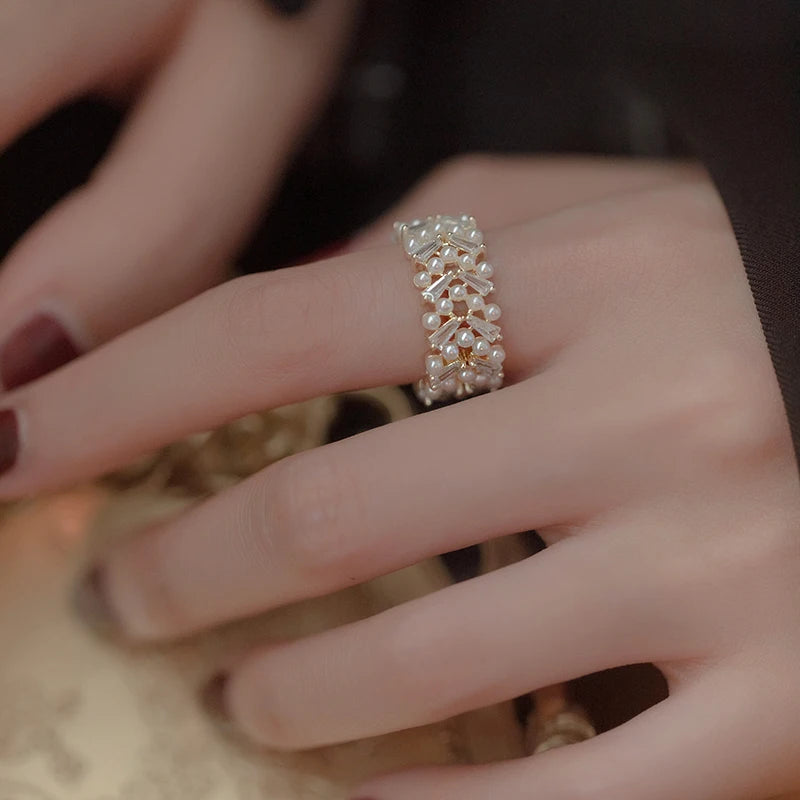 Close-up of a hand wearing a decorative ring with a blurred background