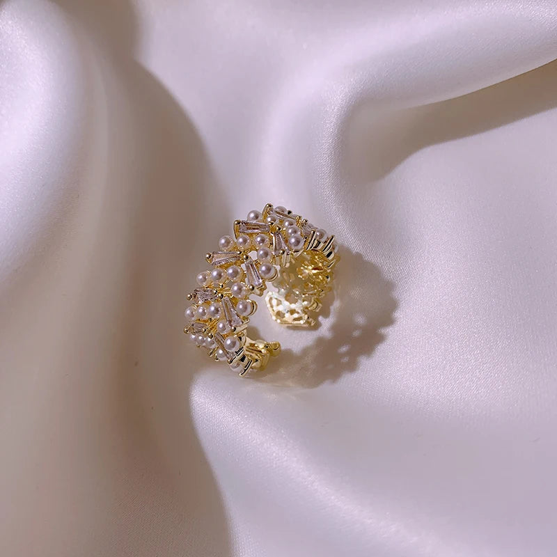 Gold and pearl ring on a white satin surface